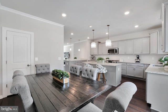 dining space featuring ornamental molding, dark wood finished floors, and recessed lighting