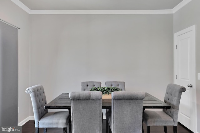 dining room with crown molding, dark wood finished floors, and baseboards