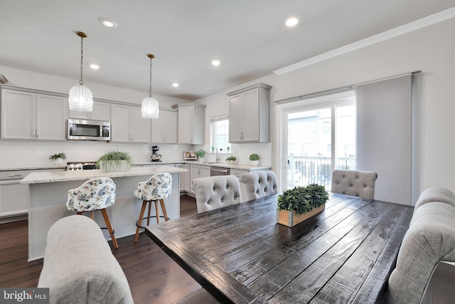 dining space featuring crown molding, dark wood-style flooring, and recessed lighting