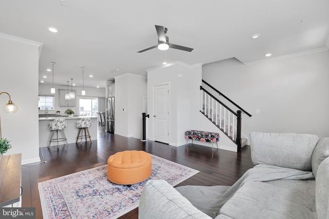 living room with crown molding, stairs, and dark wood-type flooring