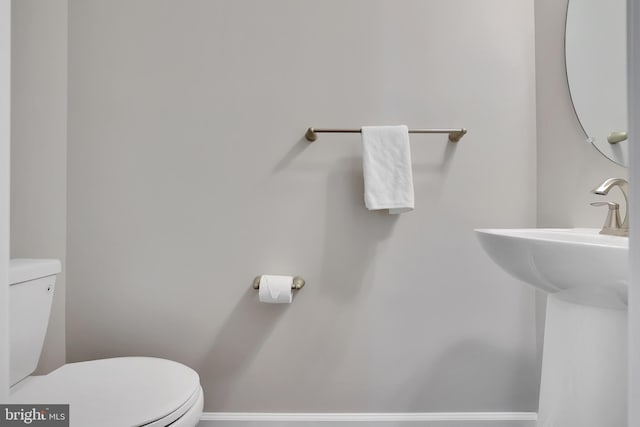 bathroom with baseboards and toilet