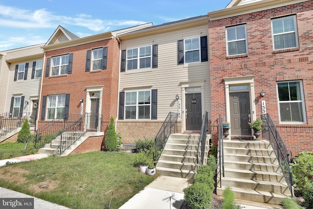 view of property with brick siding and a front lawn