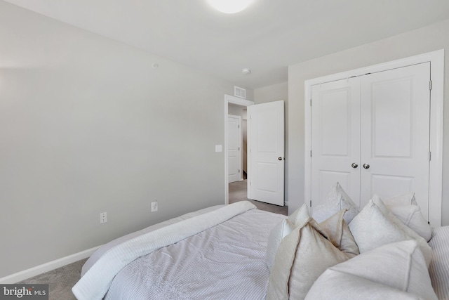 bedroom featuring a closet, carpet, visible vents, and baseboards