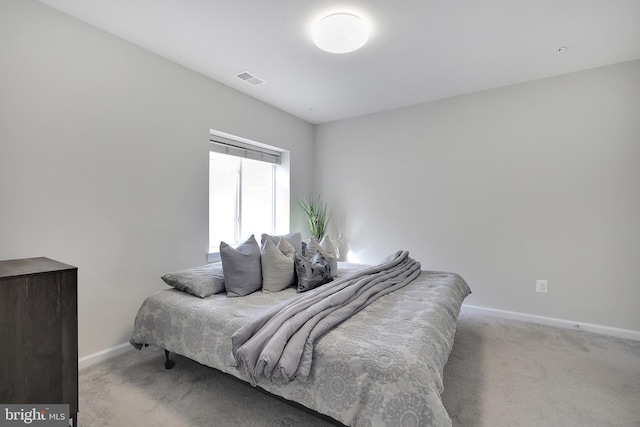 carpeted bedroom featuring visible vents and baseboards