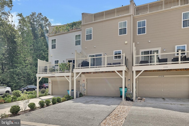 rear view of property featuring an attached garage and driveway