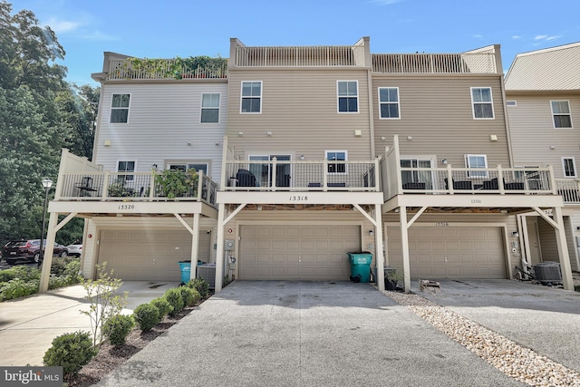 back of house with a garage, driveway, and central air condition unit