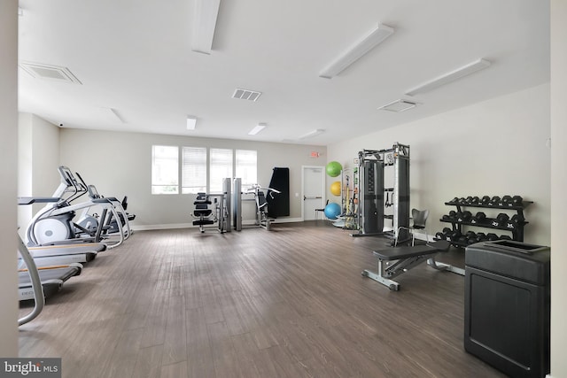 exercise room featuring visible vents, baseboards, and wood finished floors