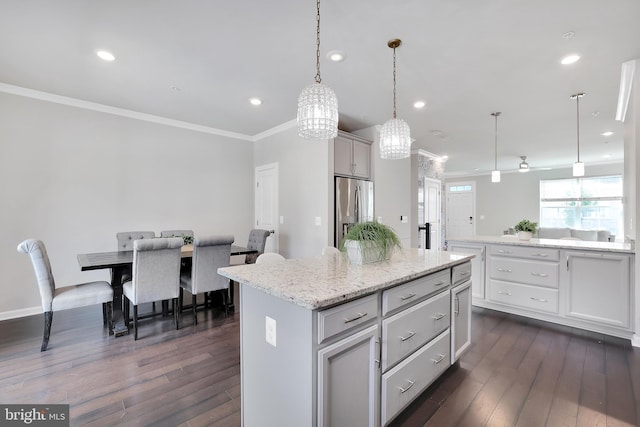 kitchen with ornamental molding, stainless steel refrigerator with ice dispenser, dark wood finished floors, and a center island