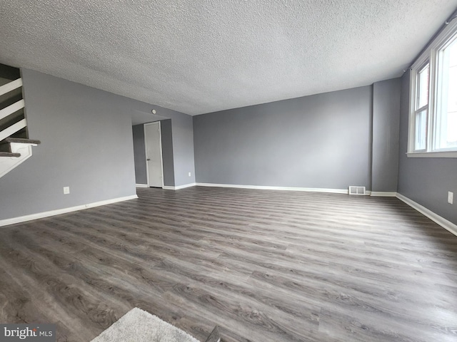 empty room featuring stairs, baseboards, and dark wood-type flooring