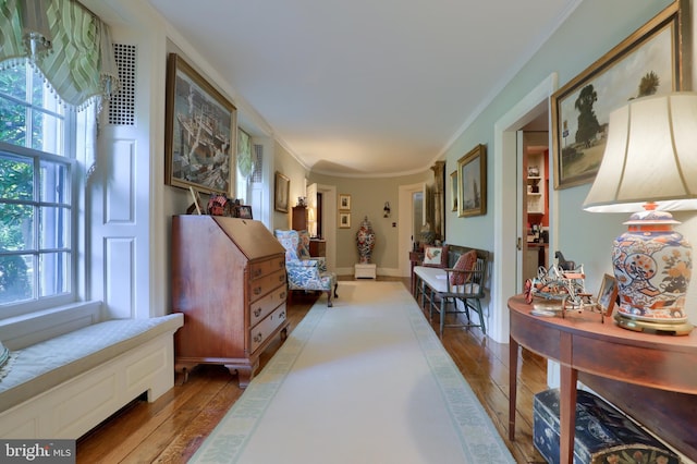 interior space with baseboards, crown molding, and hardwood / wood-style flooring