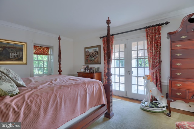 bedroom featuring french doors, wood finished floors, crown molding, and access to outside