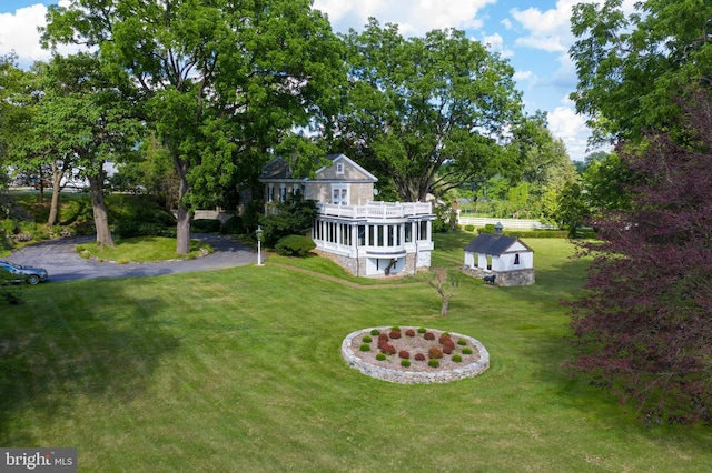 view of yard featuring driveway and a wooden deck