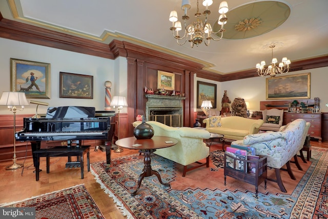 living area with ornamental molding, a fireplace, and a chandelier