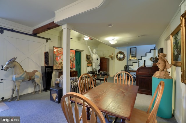 carpeted dining area featuring a barn door and visible vents