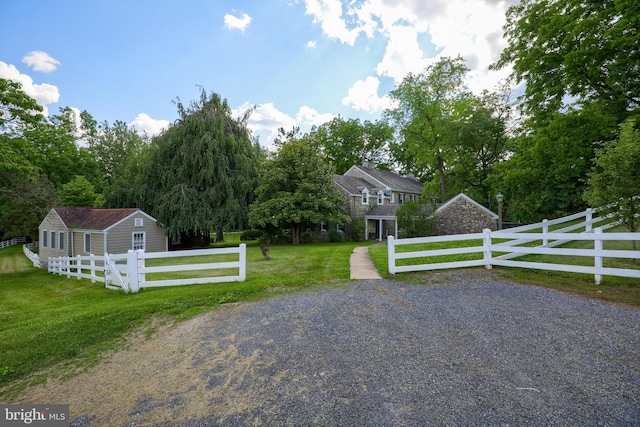 view of gate featuring a fenced front yard and a lawn