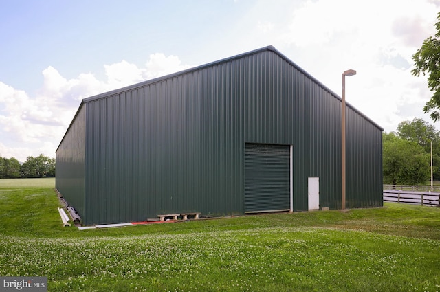 view of pole building with a yard and fence