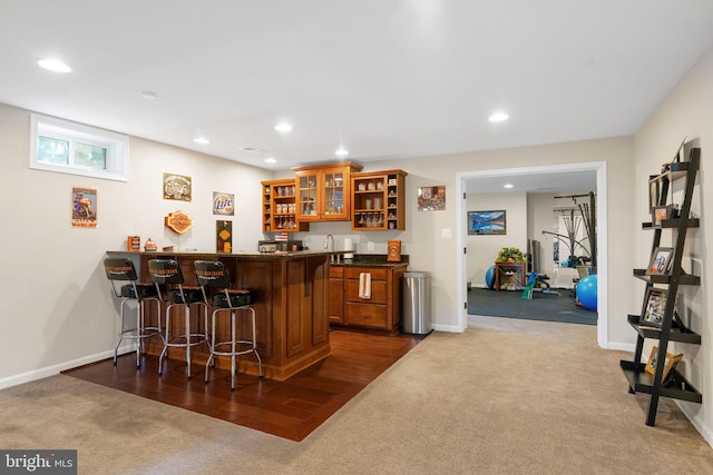 bar featuring baseboards, dark colored carpet, indoor wet bar, and recessed lighting