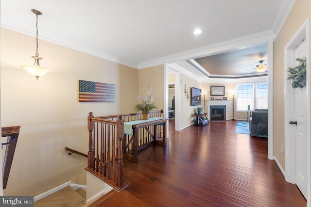 hallway with wood finished floors, an upstairs landing, and crown molding