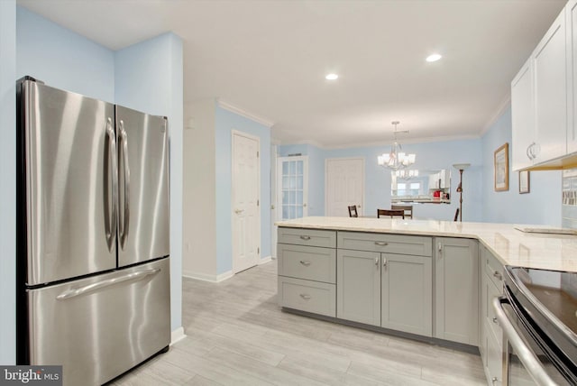 kitchen with stainless steel appliances, ornamental molding, a peninsula, and light wood-style flooring