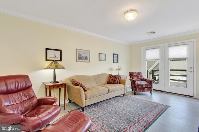 living area featuring visible vents, crown molding, and wood finished floors