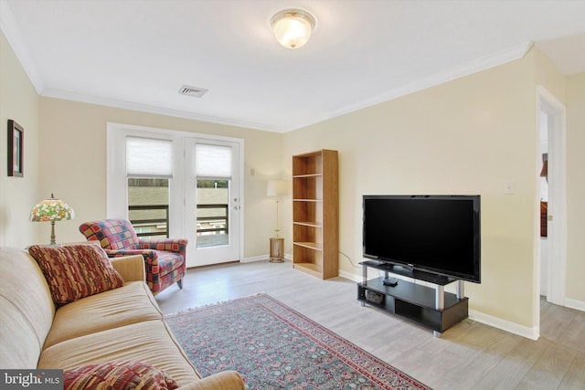 living area featuring baseboards, crown molding, visible vents, and wood finished floors