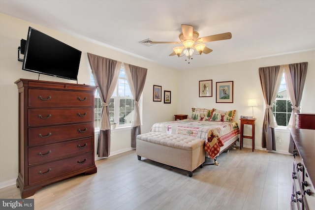 bedroom with light wood-style floors, multiple windows, and visible vents