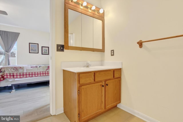 bathroom with ensuite bathroom, vanity, and baseboards