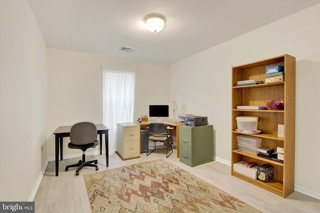 office space with baseboards, visible vents, and light wood-style floors