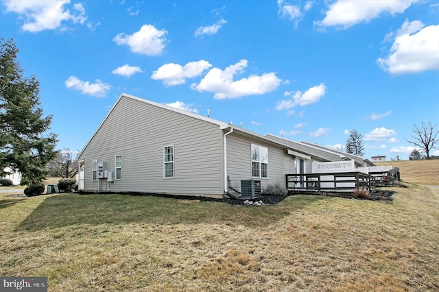 view of home's exterior with cooling unit, a yard, and a wooden deck