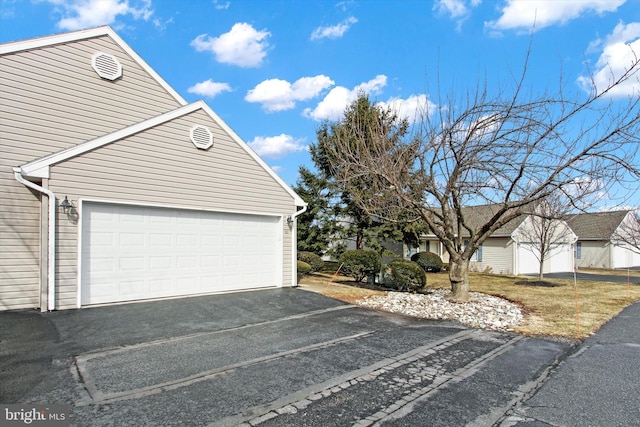 view of property exterior featuring driveway and a garage