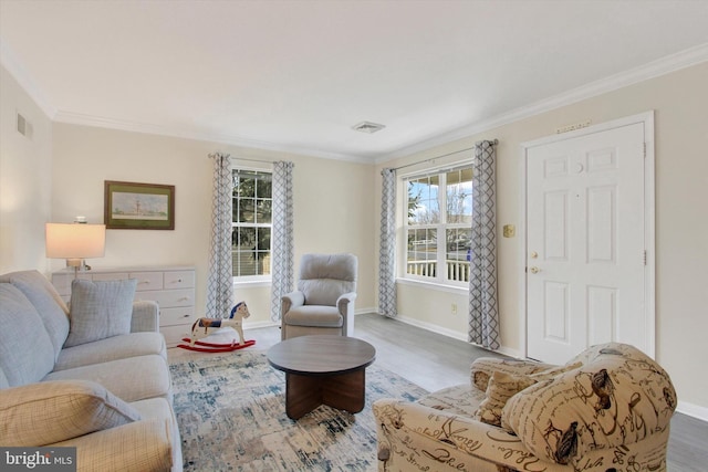 living room with visible vents, crown molding, and wood finished floors