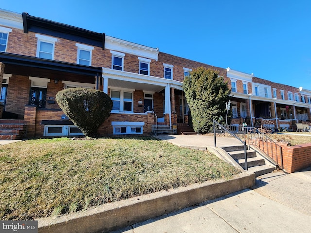 view of front of property featuring a front yard and brick siding