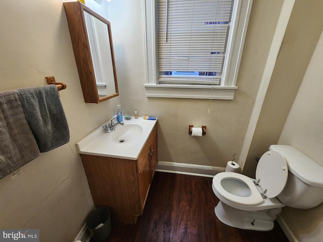 bathroom featuring toilet, baseboards, wood finished floors, and vanity