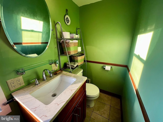 bathroom featuring tile patterned flooring, vanity, toilet, and baseboards