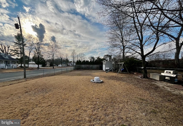 view of yard with a shed, a fenced backyard, and an outbuilding