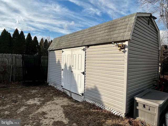 view of shed featuring fence