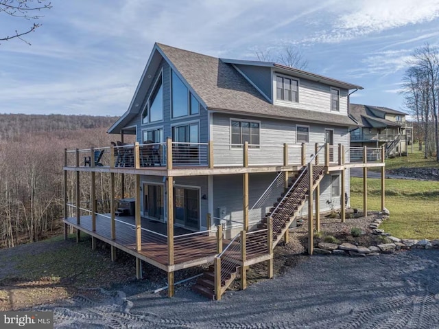 back of property featuring a wooden deck, stairway, and a shingled roof