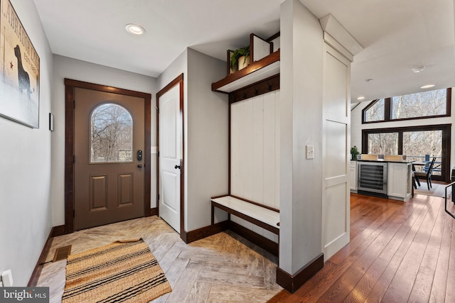 entryway with recessed lighting, baseboards, beverage cooler, and parquet flooring