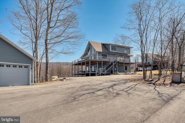 exterior space featuring stairs, aphalt driveway, and a garage