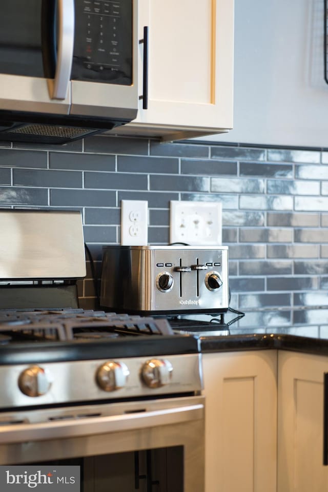 room details featuring dark countertops, backsplash, and stainless steel appliances