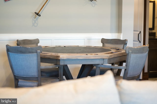 dining area with a decorative wall and wainscoting