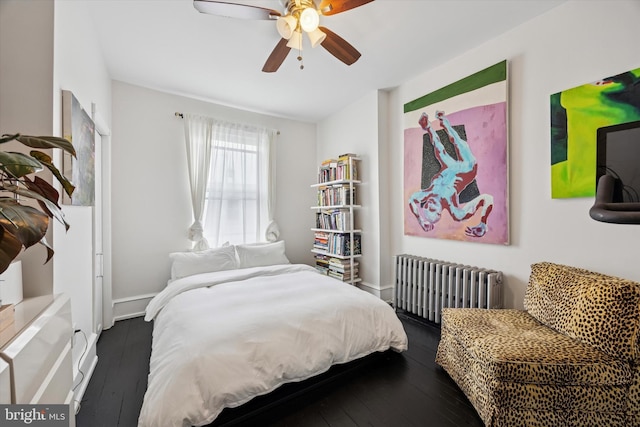 bedroom with dark wood-style floors, ceiling fan, baseboards, and radiator