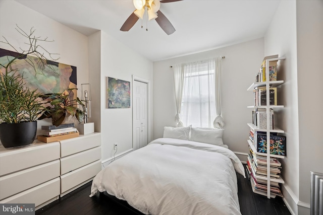 bedroom with ceiling fan, dark wood-style flooring, a closet, and baseboards