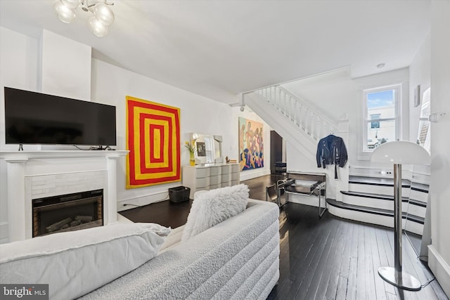 living room featuring a tile fireplace, stairway, and hardwood / wood-style flooring