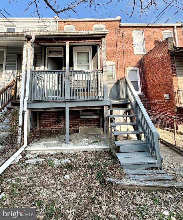 exterior space featuring brick siding, a porch, and stairs