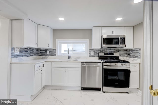 kitchen with marble finish floor, white cabinetry, appliances with stainless steel finishes, and a sink