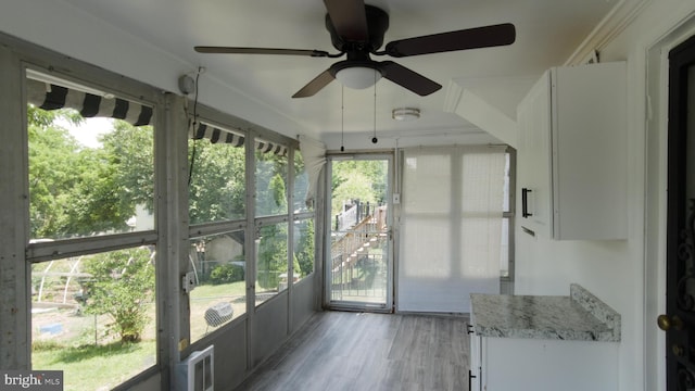 unfurnished sunroom with a ceiling fan