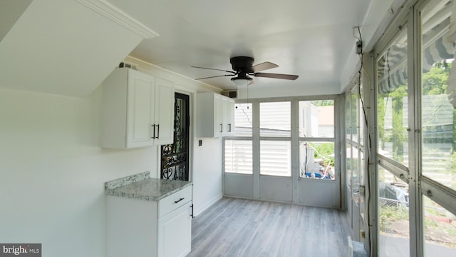 unfurnished sunroom featuring a ceiling fan