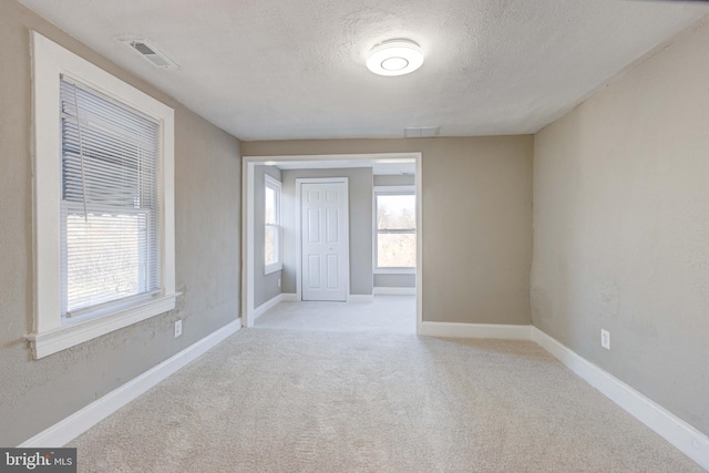 empty room featuring baseboards and a textured ceiling