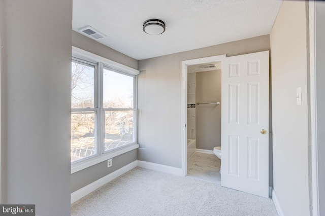 unfurnished bedroom featuring carpet flooring, visible vents, and baseboards